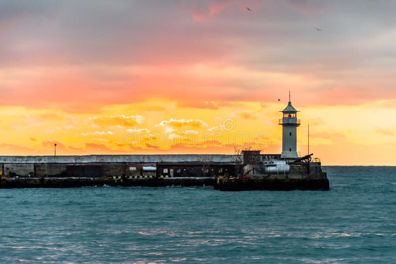 Faro sul mare all'alba immagine stock libera da diritti Faro sul mare all'alba immagine stock libera da diritti