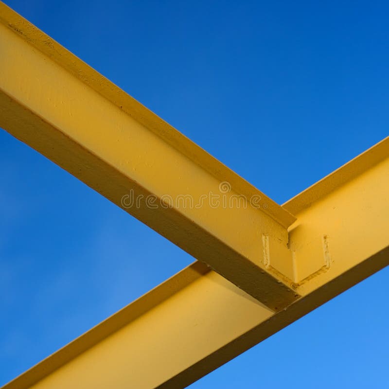 Yellow painted steel I beams against a blue sky. Yellow painted steel I beams against a blue sky