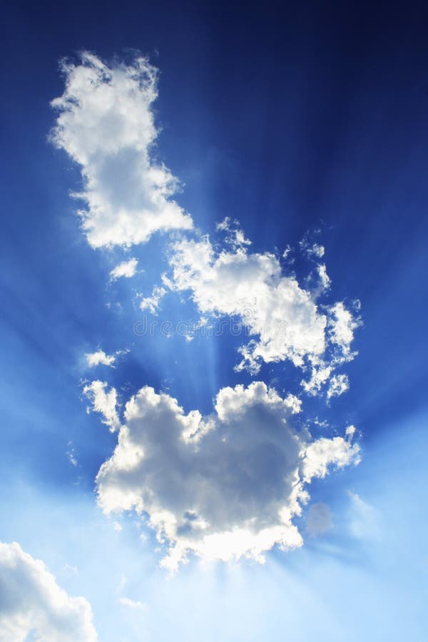 Blue sky and beams from bright sunlight behind a patch of clouds. Blue sky and beams from bright sunlight behind a patch of clouds.