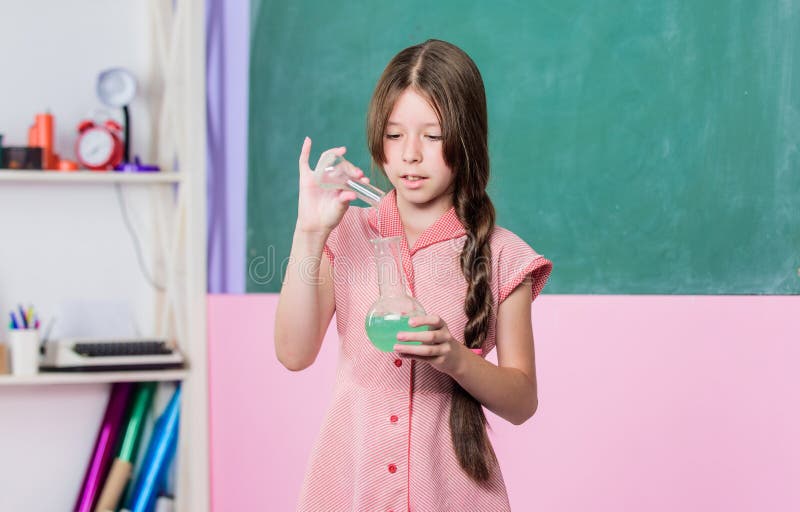 Fascinating Lesson. Small Girl With Chemical Tube. Biology Education. Girl Chemistry Class Testing Tube. Chemical