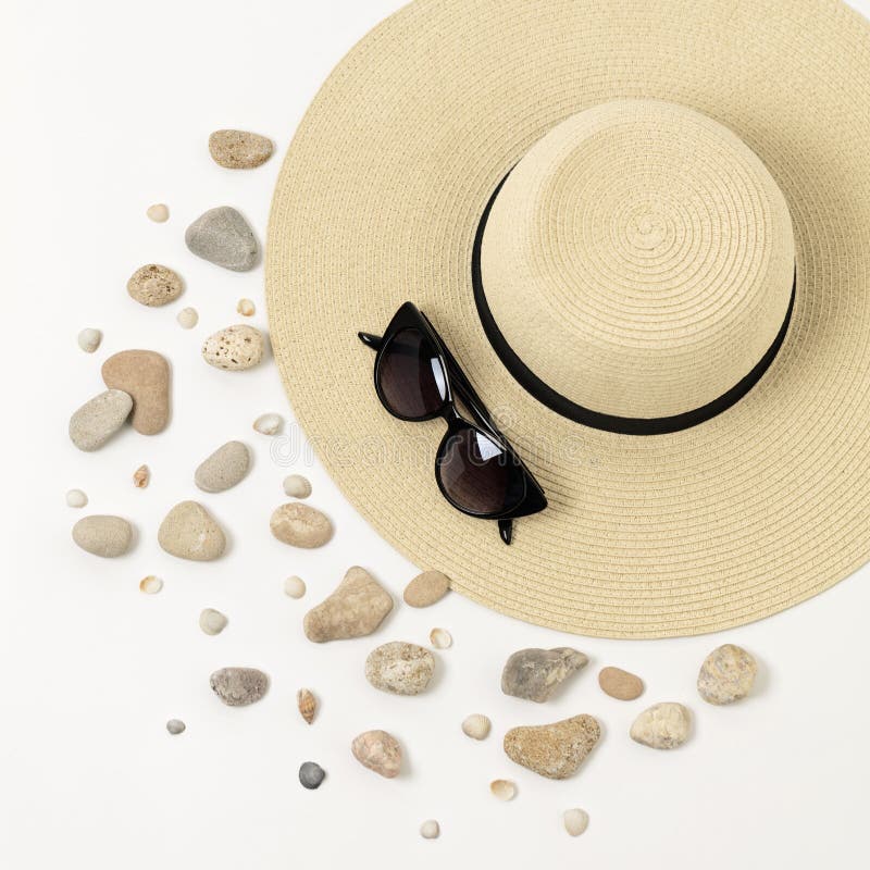 Fashion accessories - hat, sunglasses and bracelets. Marine concept sea shells and sea pebbles.