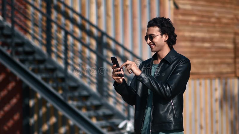 Fashion Arabic modern guy chatting smartphone social networks communication at city downtown street stock video