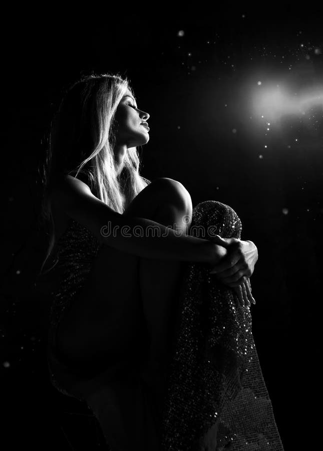 Fashion art beauty woman portrait. Beautiful girl dreaming sitting in dress with stars sparkle on dark background. Magic. Miracle