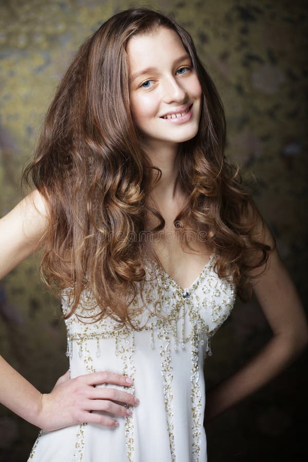 Beautiful Young Woman Model With Long Curly Hair In A White Dress