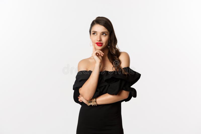 Fashion and beauty. Thoughtful young woman in black dress, smiling pleased and thinking, having an idea, white