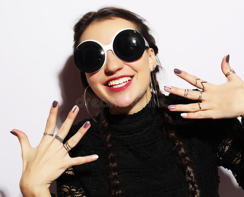 Beauty surprised fashion model girl wearing big sunglasses. Young girl. Makeup. Over white background.