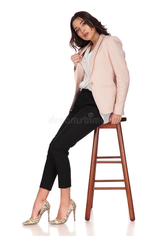 Fashion and elegant young woman pulls her collar while sitting