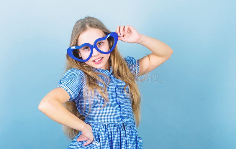 Fashion eyewear. Kid girl heart shaped eyeglasses. Girl adorable smiling face fall in love. Child charming smile blue stock images Fashion eyewear. Kid girl heart shaped eyeglasses. Girl adorable smiling face fall in love. Child charming smile blue stock images