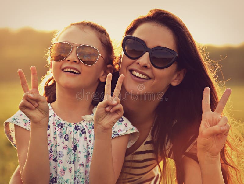 Fashion kid girl embracing her mother in trendy sunglasses and s