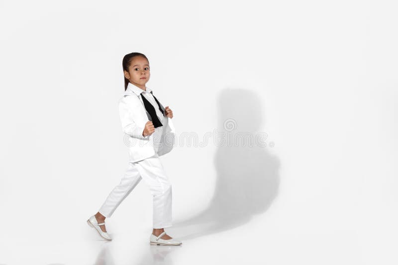 Fashion little girl model in a white suit and bow tie stock photos Fashion little girl model in a white suit and bow tie stock photos