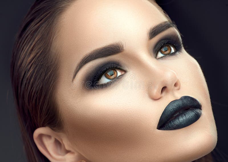Fashion model girl portrait with trendy gothic black makeup. Young woman with black lipstick, dark smokey eyes royalty free stock photography Fashion model girl portrait with trendy gothic black makeup. Young woman with black lipstick, dark smokey eyes royalty free stock photography