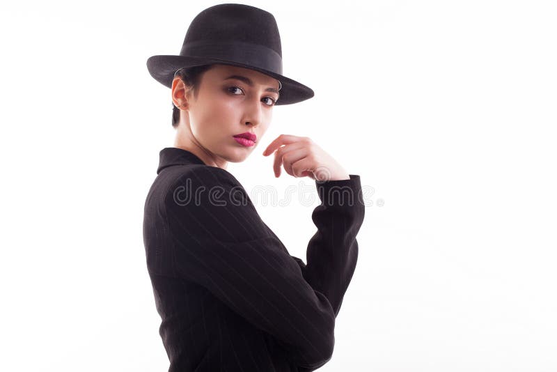 Fashion model posing looking at the camera wearing a retro hat over white background in studio