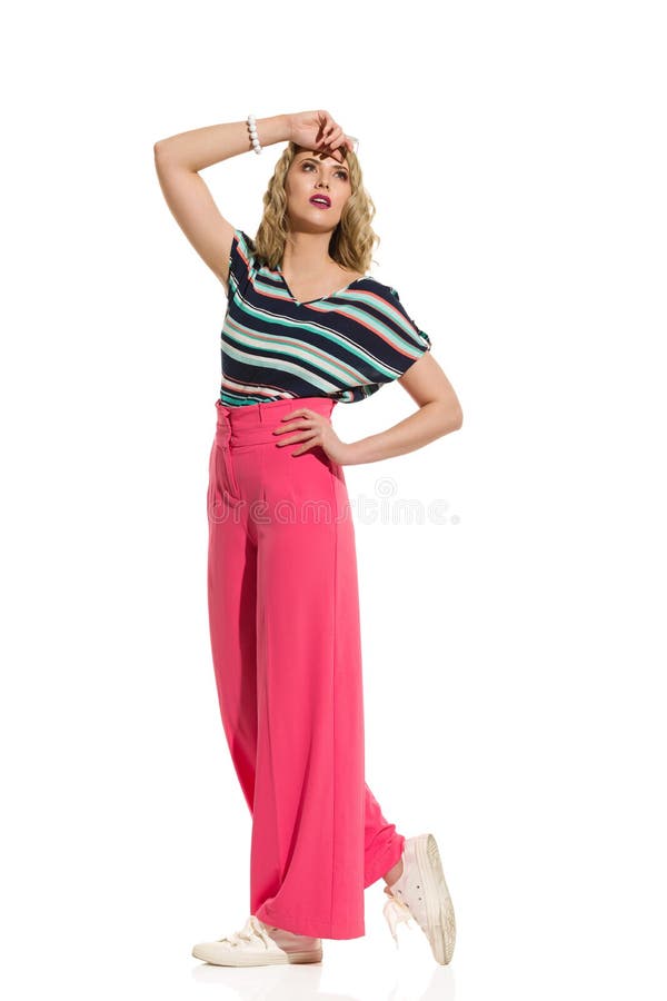 Stylish Young Woman In Red Wide Leg Trousers Is Posing In The Sunlight royalty free stock image Stylish Young Woman In Red Wide Leg Trousers Is Posing In The Sunlight royalty free stock image