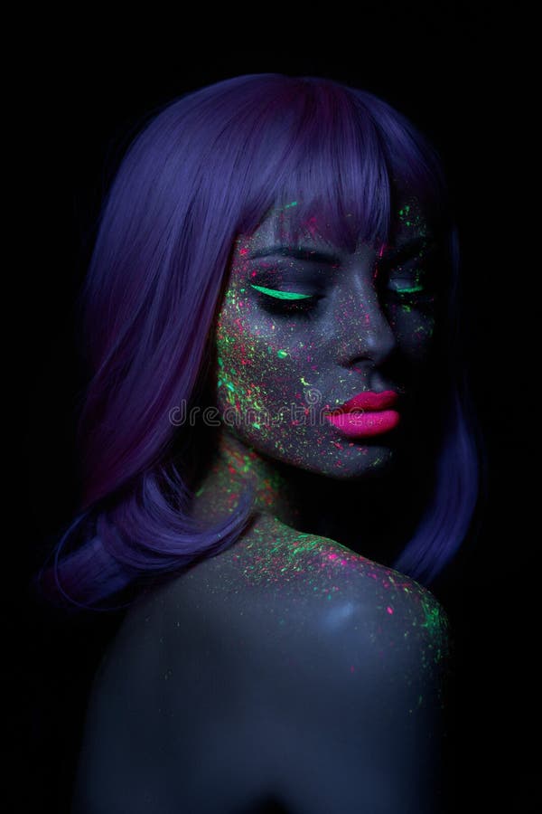 Fashion model woman in neon light bright fluorescent makeup, long hair, drop on face. Beautiful model pink hair girl colorful make royalty free stock photography Fashion model woman in neon light bright fluorescent makeup, long hair, drop on face. Beautiful model pink hair girl colorful make royalty free stock photography