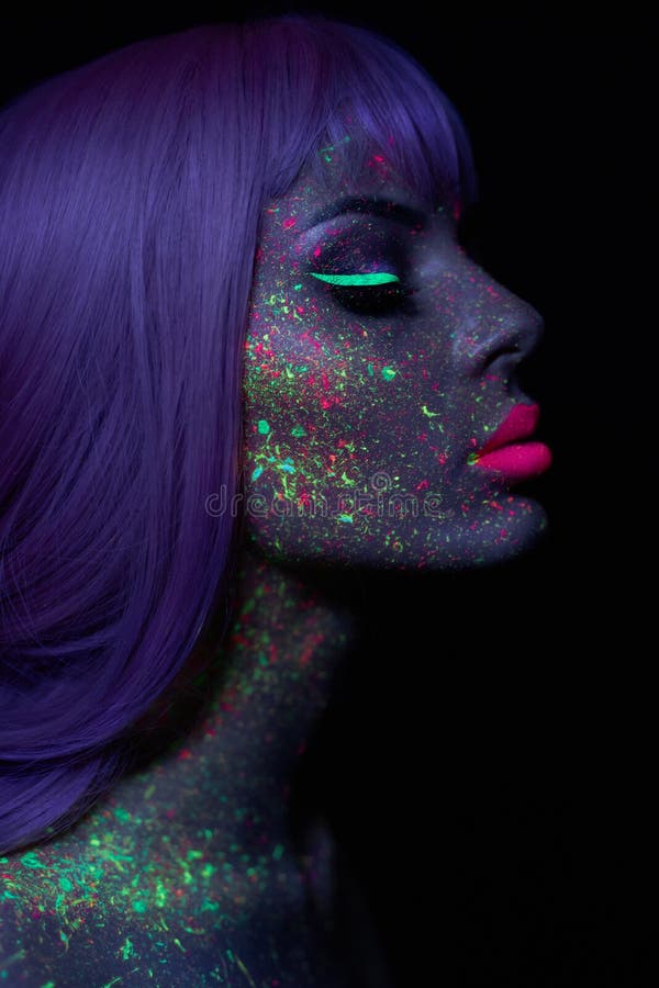 Fashion model woman in neon light bright fluorescent makeup, long hair, drop on face. Beautiful model pink hair girl colorful make stock image Fashion model woman in neon light bright fluorescent makeup, long hair, drop on face. Beautiful model pink hair girl colorful make stock image