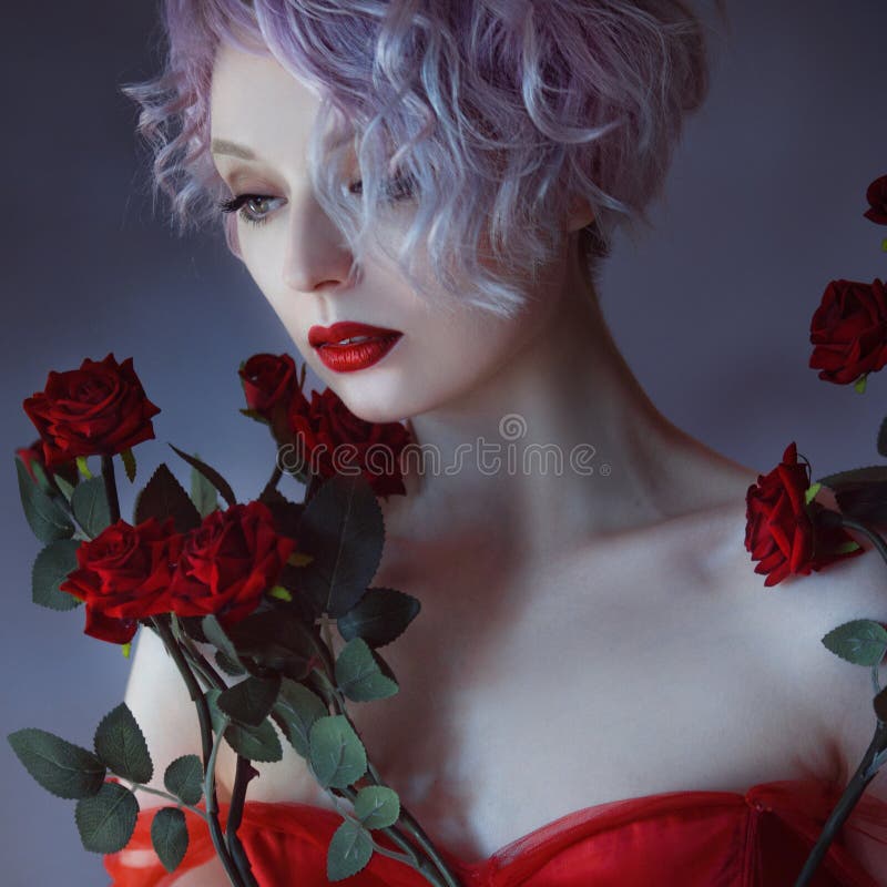 Fashion photo of young magnificent woman with red roses. Textured background.