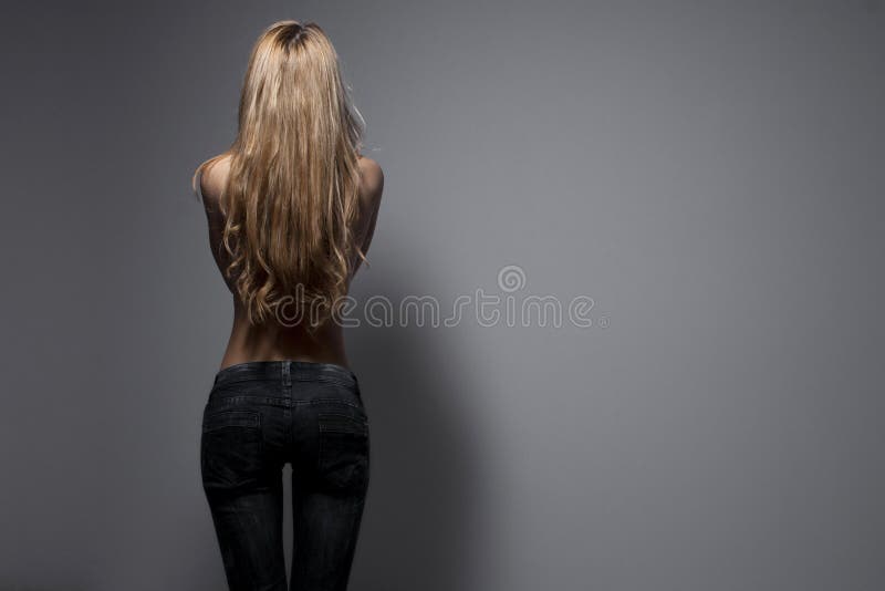 Fashion photo of a young sensual woman in jeans. Back