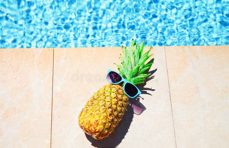 Fashion pineapple with sunglasses, blue water pool background, summer holidays, royalty free stock images Fashion pineapple with sunglasses, blue water pool background, summer holidays, royalty free stock images