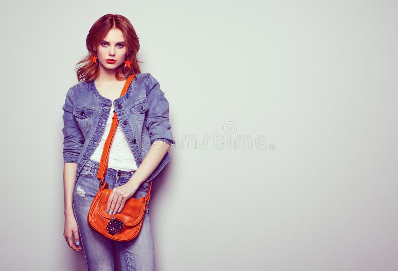 Fashion portrait of beautiful young woman with handbag