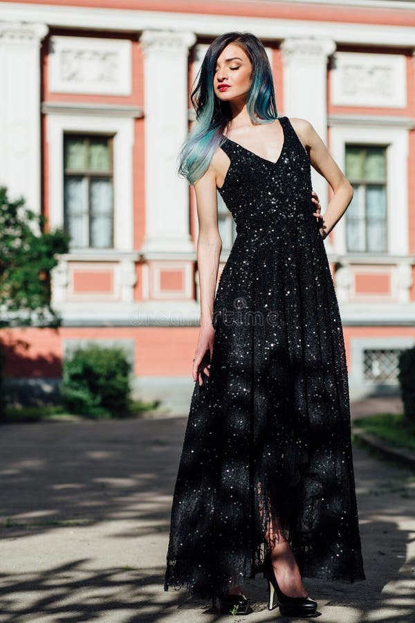 Fashion portrait of gorgeous girl with blue dyed hair long. The beautiful evening cocktail dress.