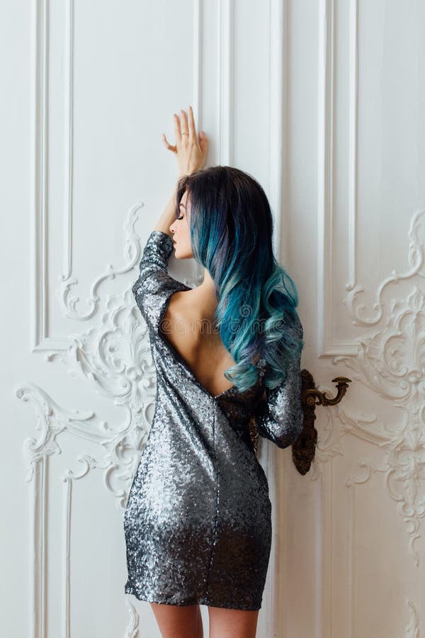 Fashion portrait of gorgeous girl with blue dyed hair long. The beautiful evening cocktail dress.