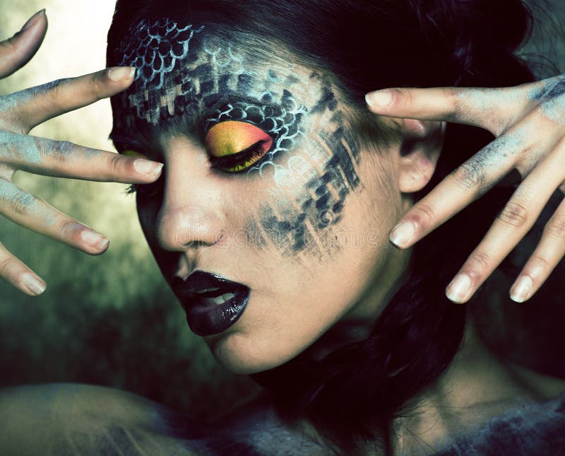 Fashion portrait of pretty young woman with creative make up like a snake, halloween concept