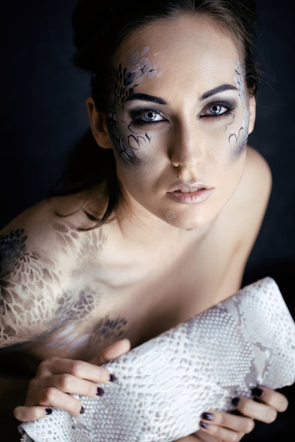 Fashion portrait of pretty young woman with creative make up like a snake