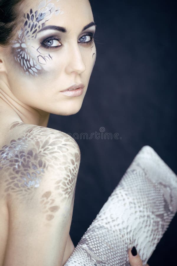 Fashion portrait of pretty young woman with creative make up like a snake