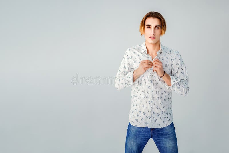 Fashion portrait of young man in white shirt poses over grey wall stock photography Fashion portrait of young man in white shirt poses over grey wall stock photography