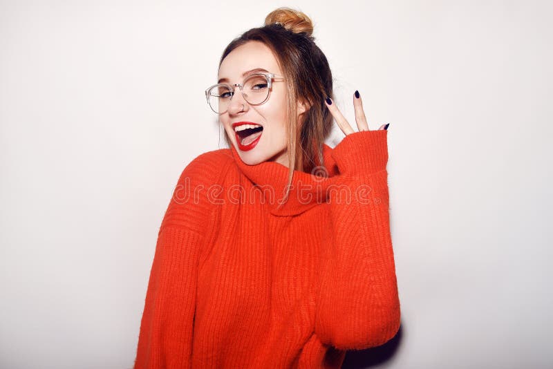 Fashion pretty cool girl wearing glasses and red sweater. Close up shot of charming female. Tender, beautiful, young. Hipster. Cut stock image Fashion pretty cool girl wearing glasses and red sweater. Close up shot of charming female. Tender, beautiful, young. Hipster. Cut stock image