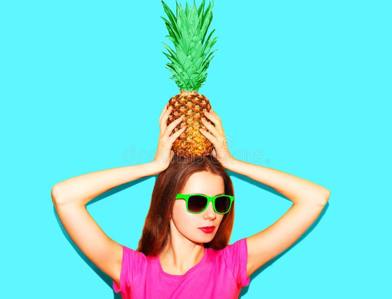 Fashion pretty woman in sunglasses with pineapple over blue stock image Fashion pretty woman in sunglasses with pineapple over blue stock image