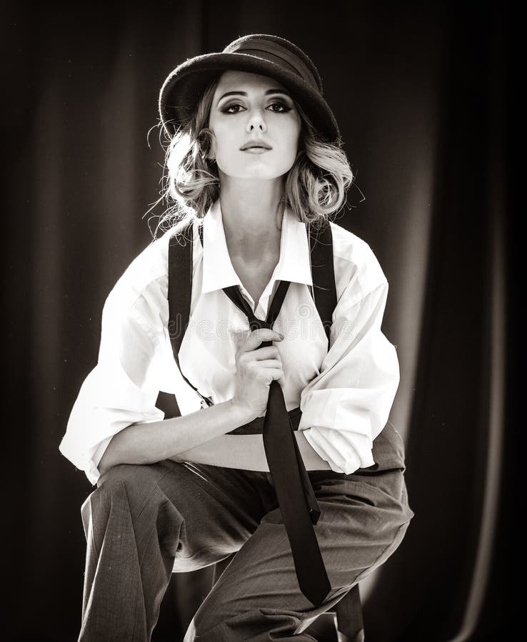 Fashion redhead girl with tie in studio.