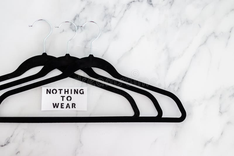 Fashion and shopping, Nothing To Wear text on group of empty clothes hangers creating geometric shape on marble background royalty free stock photos Fashion and shopping, Nothing To Wear text on group of empty clothes hangers creating geometric shape on marble background royalty free stock photos