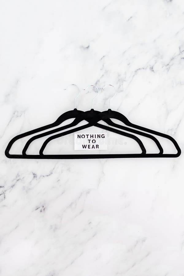 Fashion and shopping, Nothing To Wear text on group of empty clothes hangers creating geometric shape on marble background stock photos Fashion and shopping, Nothing To Wear text on group of empty clothes hangers creating geometric shape on marble background stock photos