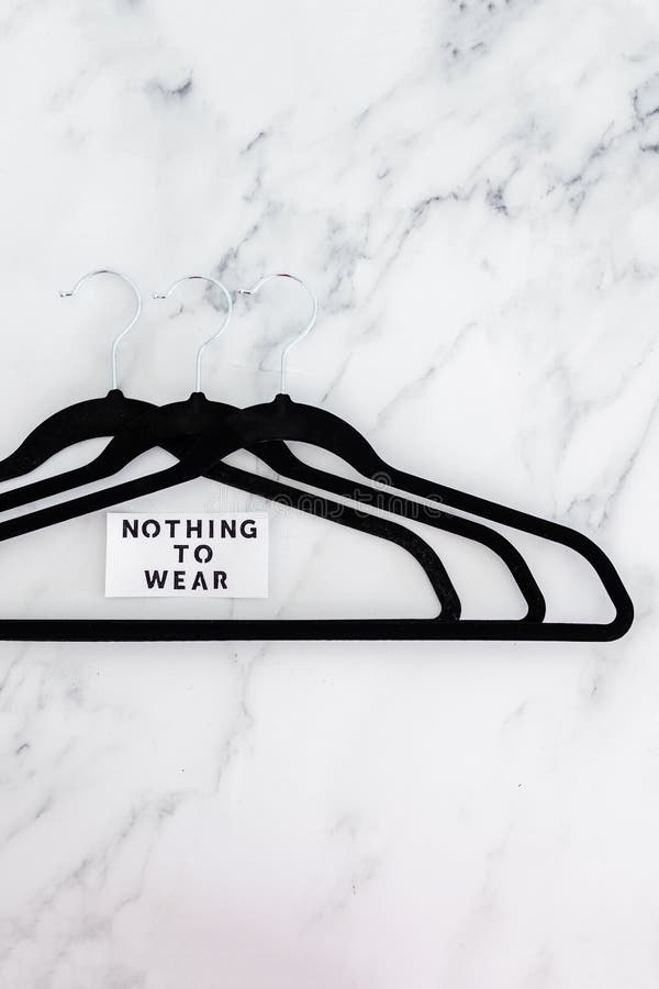 Fashion and shopping, Nothing To Wear text on group of empty clothes hangers creating geometric shape on marble background stock photos Fashion and shopping, Nothing To Wear text on group of empty clothes hangers creating geometric shape on marble background stock photos