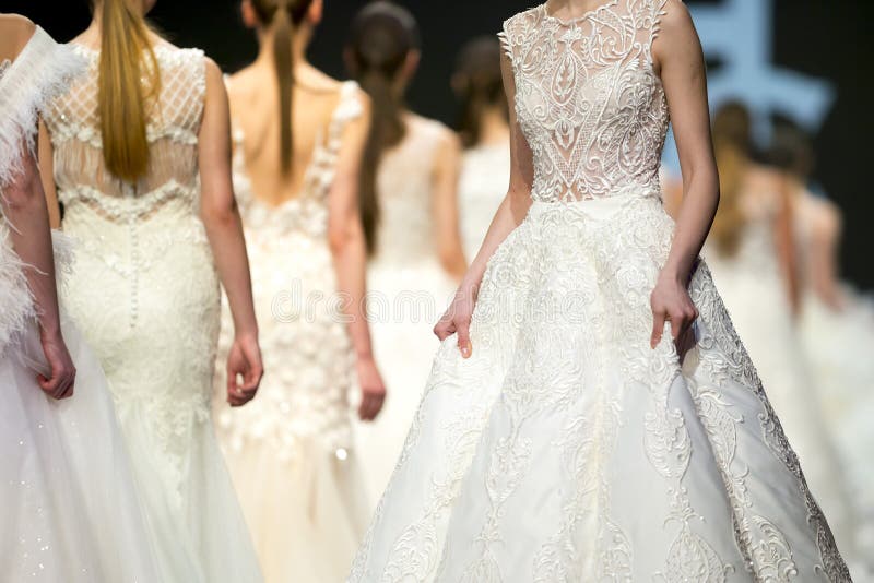 Žena modely chůze dráhu v krásný stylový bílý svatba šaty během móda ukázat.