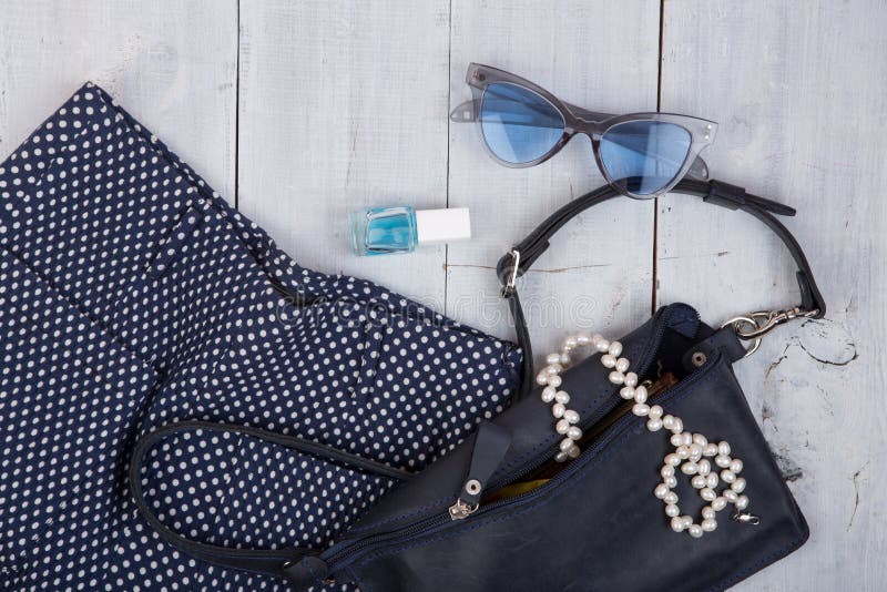 fashion stuff - bag, trousers, sunglasses, nail polish, pearl jewelry on white wooden background royalty free stock photos fashion stuff - bag, trousers, sunglasses, nail polish, pearl jewelry on white wooden background royalty free stock photos