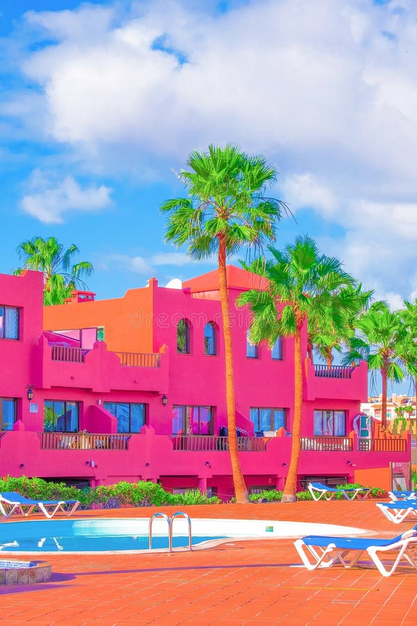 Fashion tropical minimal location. Pink Hotel, swimming pool and Palm. Summer blue sky. Canary islands.  Travel aesthetics