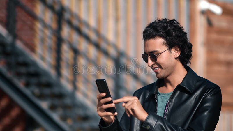 Fashion Turkish guy chatting smartphone positive emotion downtown street outdoor summer cityscape stock footage