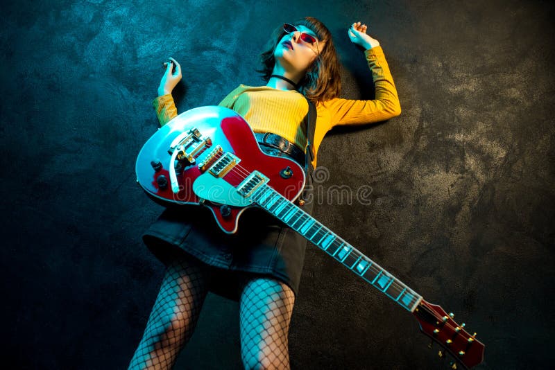 Fashion Young Hipster Woman with Curly Hair with Red Guitar in Neon Lights. Rock Musician is Playing Electrical Guitar Stock Photo - Image of nineties, expression: 149592302 Fashion Young Hipster Woman with Curly Hair with Red Guitar in Neon Lights. Rock Musician is Playing Electrical Guitar Stock Photo - Image of nineties, expression: 149592302