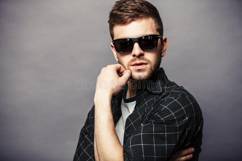 Fashion Young Man Holding His Fashionable Sunglasses on Gray Stock ...