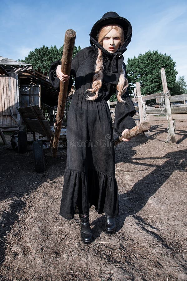 Fashion young woman wearing stylish black dress and hat at countryside. Amish fashion style. stock images Fashion young woman wearing stylish black dress and hat at countryside. Amish fashion style. stock images