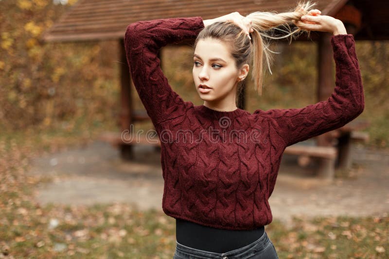Fashionable beautiful young woman in a vintage sweater outdoors