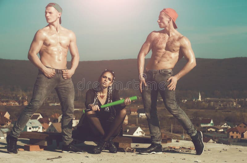 Fashionable criminal woman and muscular men with baseball bat royalty free stock photos Fashionable criminal woman and muscular men with baseball bat royalty free stock photos