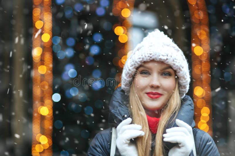 Fashionable lady walking at the winter fair with snowflakes stock photo