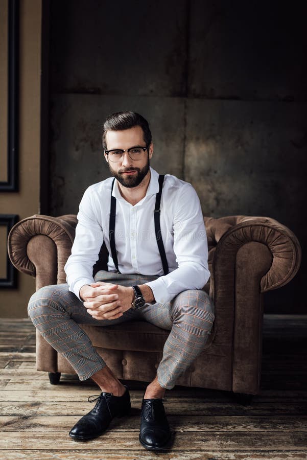 Fashionable Man in Glasses and Suspenders Sitting Stock Photo - Image ...