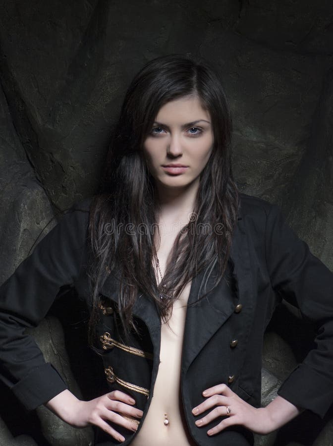 Fashionable portrait of a brunette girl over rock background. stock images