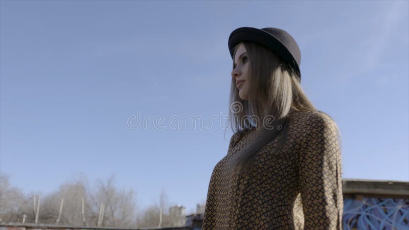 Fashionable young woman model in hat posing on camera. Action. Outdoor portrait of young beautiful fashionable woman stock photo Fashionable young woman model in hat posing on camera. Action. Outdoor portrait of young beautiful fashionable woman stock photo