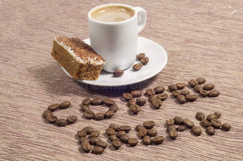 Words coffee Break written in whole coffee beans with a cup of coffee and cappuccino cake on the side. Words coffee Break written in whole coffee beans with a cup of coffee and cappuccino cake on the side