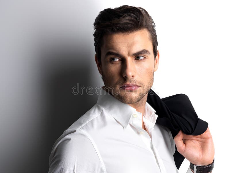 Fasonuje młodego człowieka w białych koszula chwytach czarna kurtka
